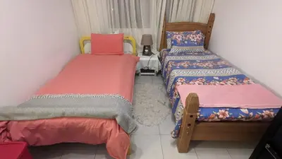 a bedroom with two beds and a table with a lamp at Shared Top 1st floor villa in Limassol