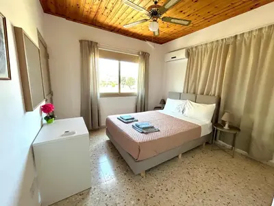 a bedroom with a bed and a ceiling fan at Himonas Apartments in Pissouri
