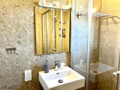 a bathroom with a sink and a mirror and a shower at Himonas Apartments in Pissouri