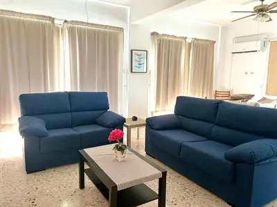 a living room with two blue couches and a table at Himonas Apartments in Pissouri