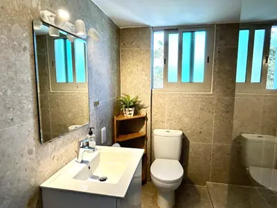 a bathroom with a sink and a toilet and a mirror at Himonas Apartments in Pissouri