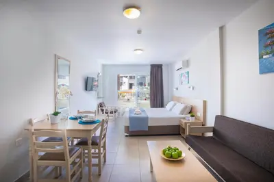 a living room with a bed and a dining room at Christabelle Hotel Apartments in Ayia Napa