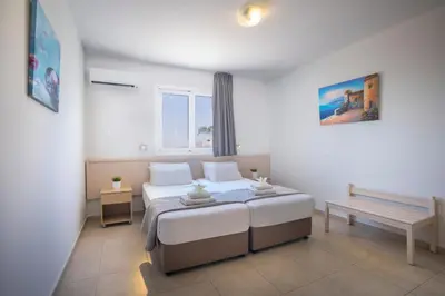 a bedroom with a bed and a bench in it at Christabelle Hotel Apartments in Ayia Napa