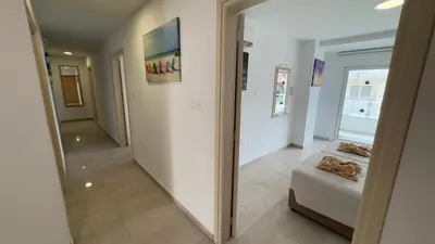 a hallway with a mirror and a bed in a room at Christabelle Hotel Apartments in Ayia Napa