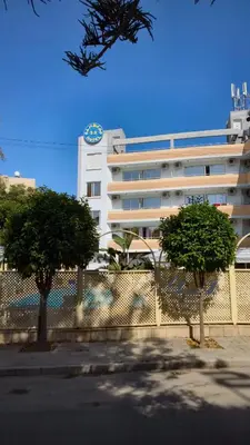 a white building with a clock on top of it at San Remo Hotel in Larnaka