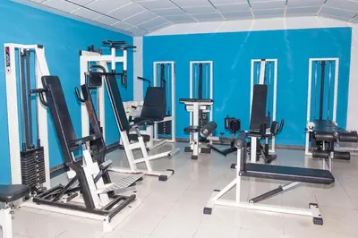 a gym with a blue wall and several tread machines at San Remo Hotel in Larnaka