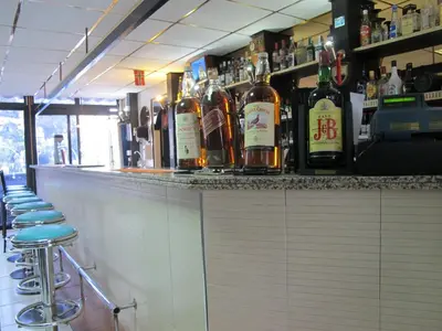 a bar with bottles of alcohol on the counter at San Remo Hotel in Larnaka