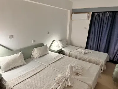 a hotel room with two beds and a window at San Remo Hotel in Larnaka