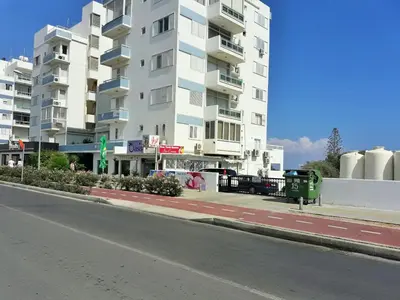 a large white apartment building on a city street at 16 SANDY BEACH in Larnaka