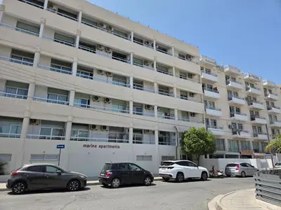 a parking lot with cars parked in front of a building at One Bedroom aptm Larnaca in Larnaka