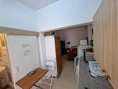 a small kitchen with a table and a refrigerator at Nicosia rooms Studios in Nicosia
