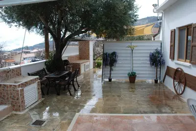 a patio with a white garage and a tree at Kanarinis House in Omodos