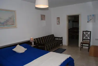 a bedroom with a blue bed and a couch at Kanarinis House in Omodos