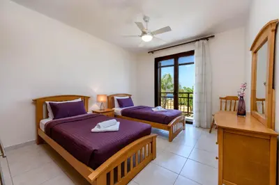 two beds in a room with a window at Villa Greco Mare #5 in Paralimni