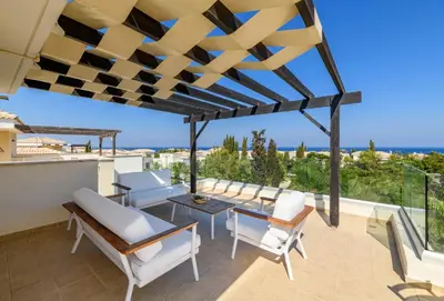 a patio with a table and chairs and a view of the ocean at Villa Greco Mare #5 in Paralimni