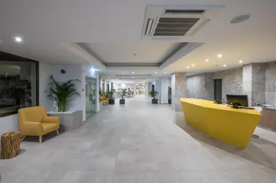 an office lobby with a yellow desk and chairs at Narcissos Waterpark Resort in Protaras