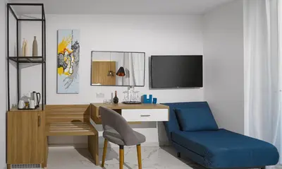 a room with a desk and a chair and a tv at The Blue Ivy Hotel & Suites in Protaras