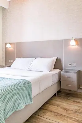 a bedroom with a bed with a green blanket on it at Limassol Marina Nereids D22 by Ezoria Villas in Limassol