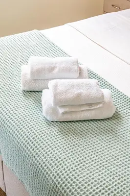 two towels are sitting on top of a bed at Limassol Marina Nereids D22 by Ezoria Villas in Limassol