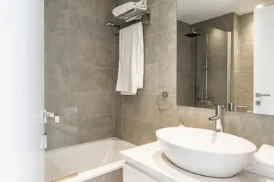 a bathroom with a white sink and a bath tub at Limassol Marina Nereids D22 by Ezoria Villas in Limassol