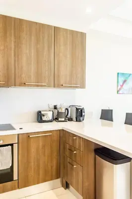 a kitchen with wooden cabinets and white counter tops at Limassol Marina Nereids D22 by Ezoria Villas in Limassol