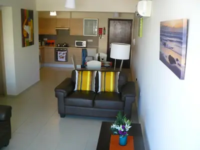 a living room with a couch and a table at Pyla Gardens E107 in Pyla