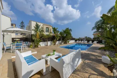 a villa with a swimming pool and a house at Protaras Holiday Villa Alexa in Protaras