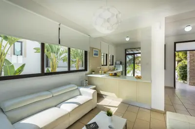 a living room with a couch and a kitchen at Protaras Holiday Villa Alexa in Protaras
