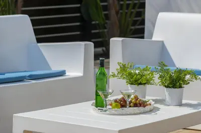 a table with a bottle of wine and a plate of fruit at Protaras Holiday Villa Alexa in Protaras