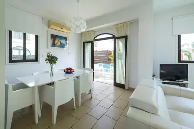 a white living room with a white table and a couch at Protaras Holiday Villa Alexa in Protaras