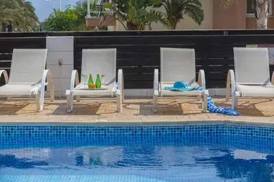a group of chairs sitting next to a swimming pool at Protaras Holiday Villa Alexa in Protaras