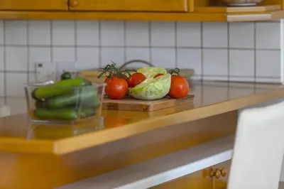 a counter with tomatoes cucumbers and other vegetables on it at Protaras Beachfront Sirina Lina Suite in Paralimni