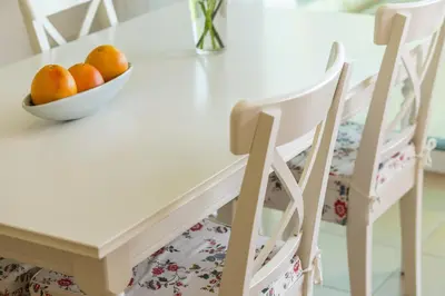 a white dining room table with a bowl of oranges at Protaras Beachfront Sirina Lina Suite in Paralimni