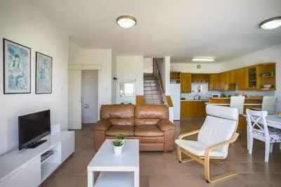 a living room with a couch and a table at Protaras Beachfront Sirina Lina Suite in Paralimni