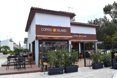 a coffee shop with tables and chairs in front of it at Christos beach house in Larnaka