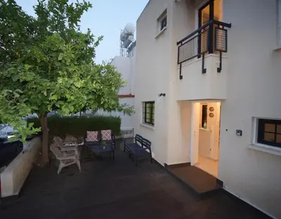 a patio with a table and chairs next to a building at Christos beach house in Larnaka