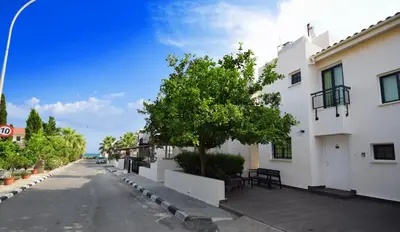 an empty street with a tree and a building at Christos beach house in Larnaka