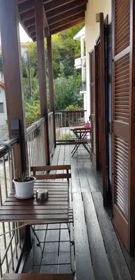 a wooden porch with a bench and a table at Kalopanayiotis Museum Inn in Kalopanayiotis