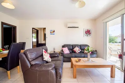 a living room with a couch and a table at Mythical Sands Apartments in Protaras