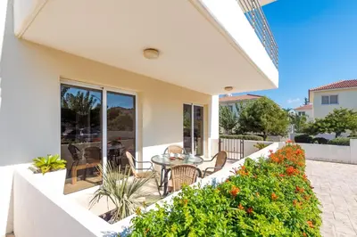 a house with a patio with a table and chairs at Mythical Sands Apartments in Protaras