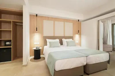 a bedroom with a large bed with pillows at Maris Grand Waterpark Resort in Protaras