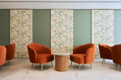 a waiting room with orange chairs and a table at Maris Grand Waterpark Resort in Protaras