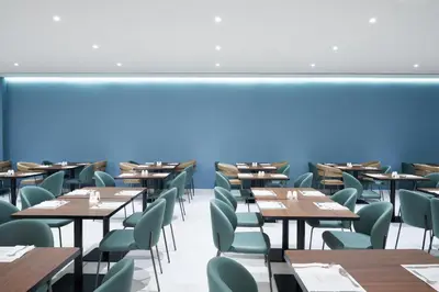 a dining room with wooden tables and chairs at Maris Grand Waterpark Resort in Protaras