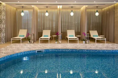 a swimming pool in a hotel room with chairs at Vangelis Hotel & Suites in Protaras