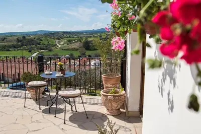 a balcony with a table and chairs and flowers at Samareitidos Light Cottage in Anaphotia
