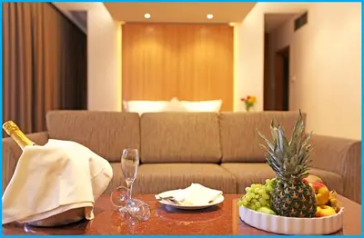 a table with a bowl of fruit and a couch at Poseidonia Beach Hotel in Limassol