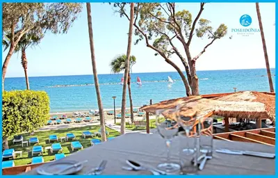 a table with a view of the beach and the ocean at Poseidonia Beach Hotel in Limassol