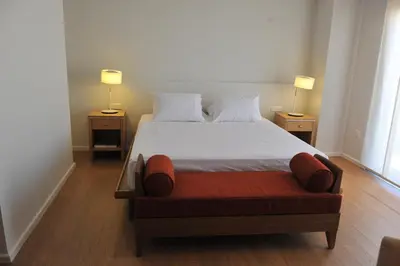 a bedroom with a bed with two lamps on two tables at E-Hotel Larnaca Resort & Spa in Larnaka