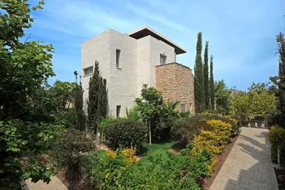 a house in a garden with trees and bushes at E-Hotel Larnaca Resort & Spa in Larnaka
