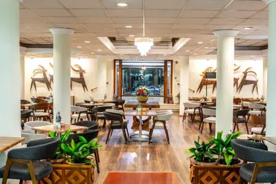 a restaurant with tables and chairs and plants at Forest Park Hotel in Platres